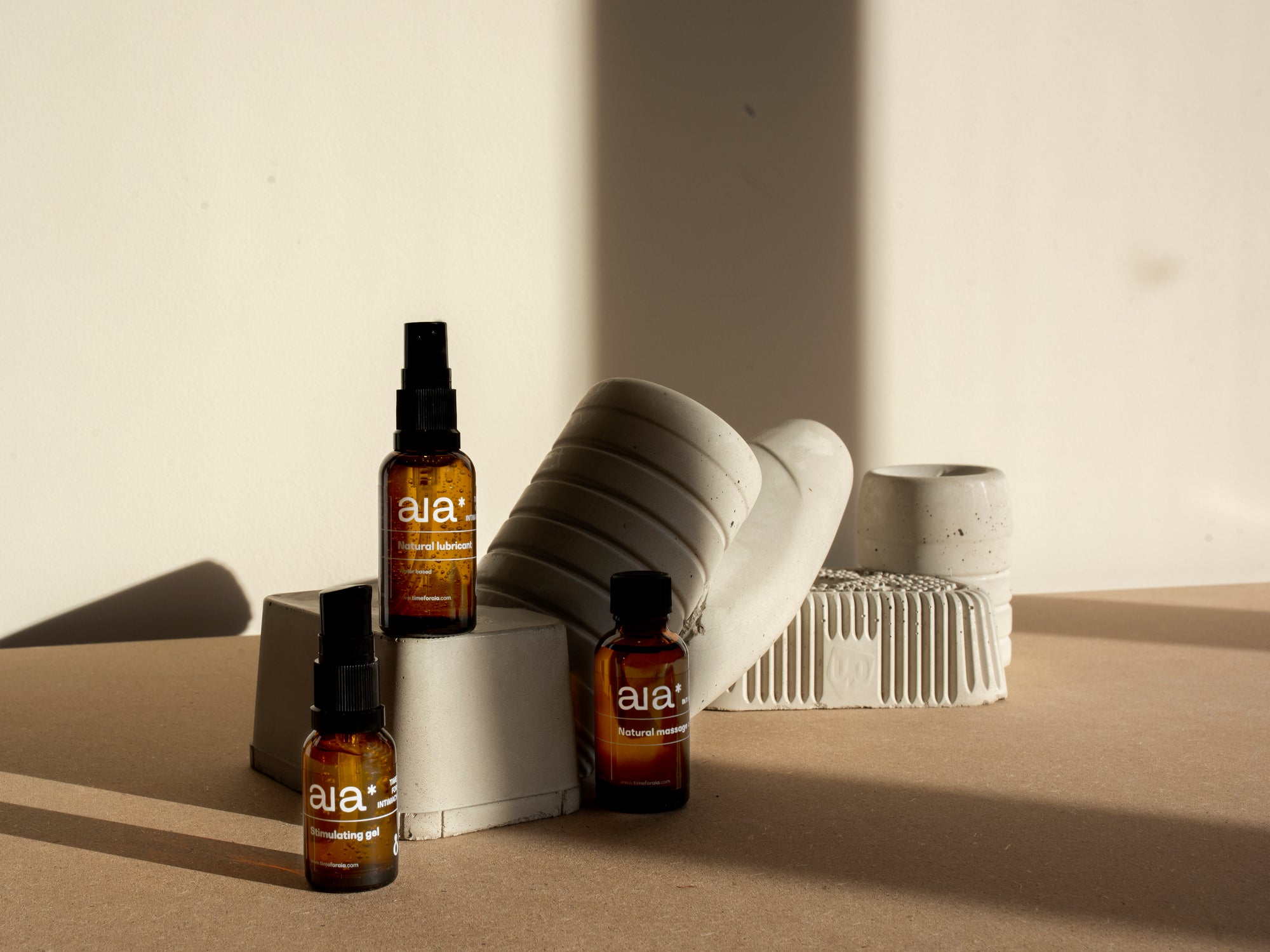 Aia Intimacy Essentials Box displayed with natural lubricant, massage oil, and stimulating gel bottles.
