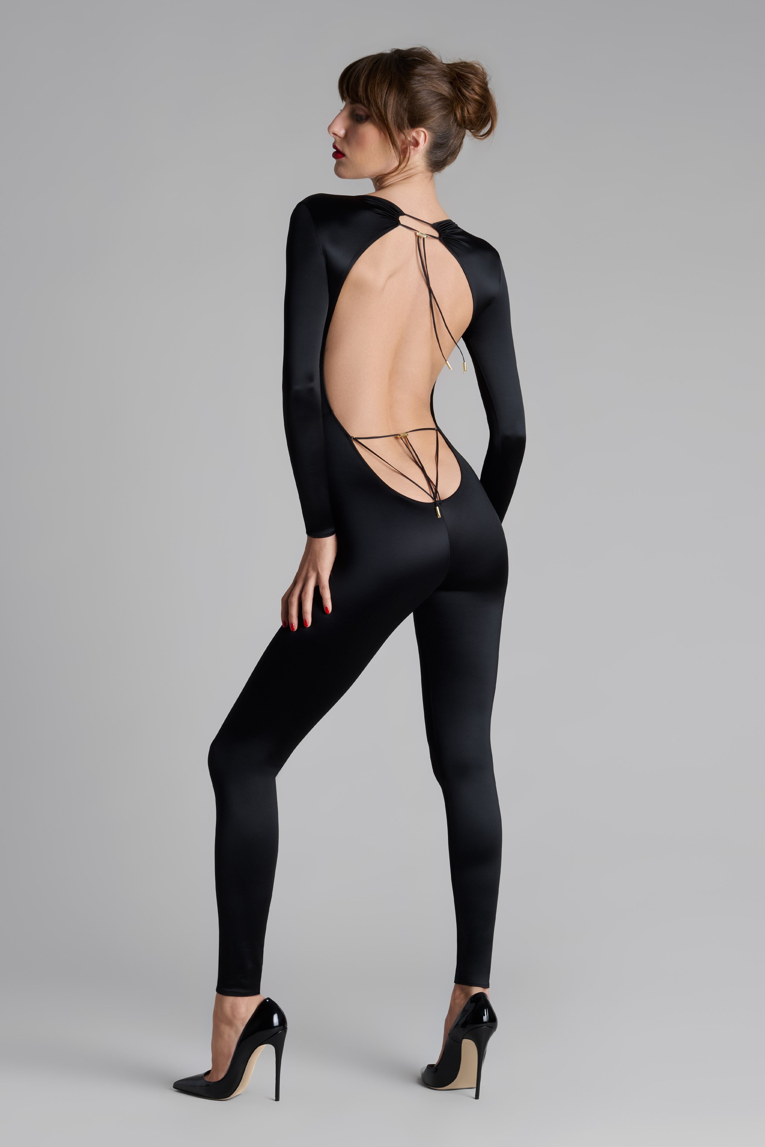 Model wearing French Kiss black lace catsuit – seductive lingerie NZ, styled with suspenders, stockings, and flirty lingerie accessories.