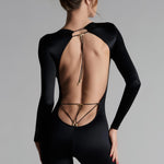 A model wearing a long sleeve open back black catsuit with satin softness and unique style, featuring triangle cups and adjustable straps.