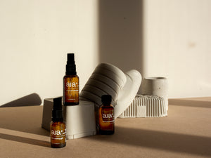 Aia Intimacy Essentials Box displayed with natural lubricant, massage oil, and stimulating gel bottles.