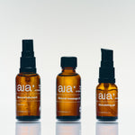 Aia Intimacy Box contents: amber glass bottles of natural lubricant, massage oil, and stimulating gel.